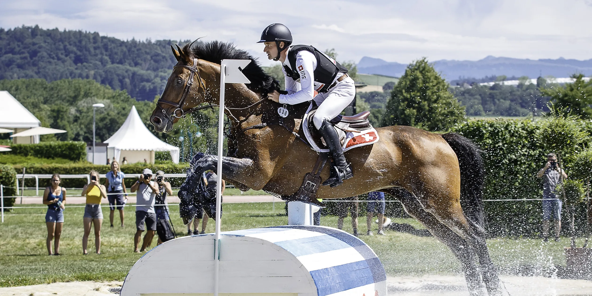SUI-Robin Godel rides Grandeaur de Lully CH during the Cross Country for the CCIO4*-S FEI Nations Cup Eventing - Switzerland. Interim-1st. 2022 SUI-Avenches Horse Trials. Saturday 9 July 2022. Copyright Photo: Libby Law Photography